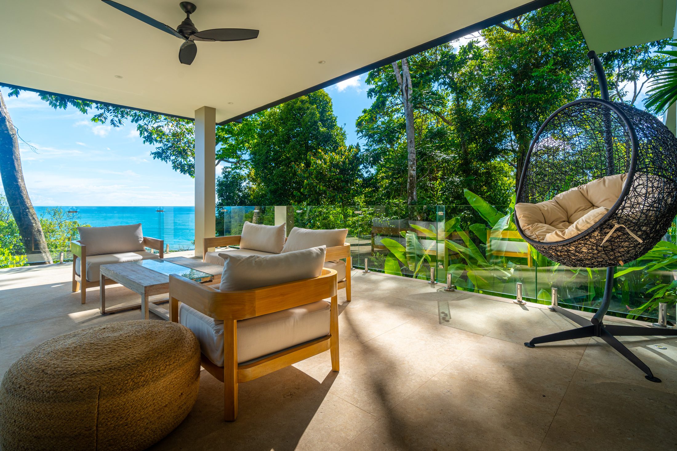 Covered terrace with hanging chair and ocean view